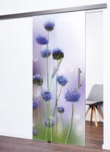 Moderne, schöne Ganzglasschiebetür Modell "Flowers" 9040. Komplette Scheibe undurchsichtig mit Motiv von mehreren lilafarbigen Blumen. Mit Laufschiene in Edelstahl-Look und rundem Edelstahl-Stoßgriff.